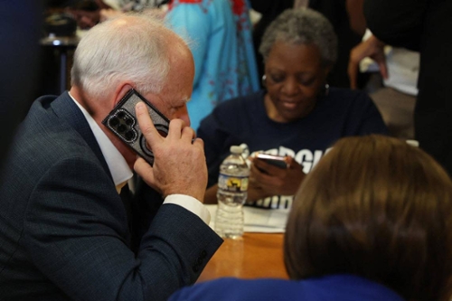 Minnesota governor and Democratic vice presidential candidate Tim Walz speaks to a voter while phone banking at the Macon Bibb County Democratic Committee office on Tuesday, Sept. 17, 2024, in Macon, Georgia. CREDIT: The Telegraph